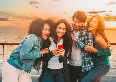 Un groupe de jeunes croisiéristes se prend en photo sur le pont d'un navire